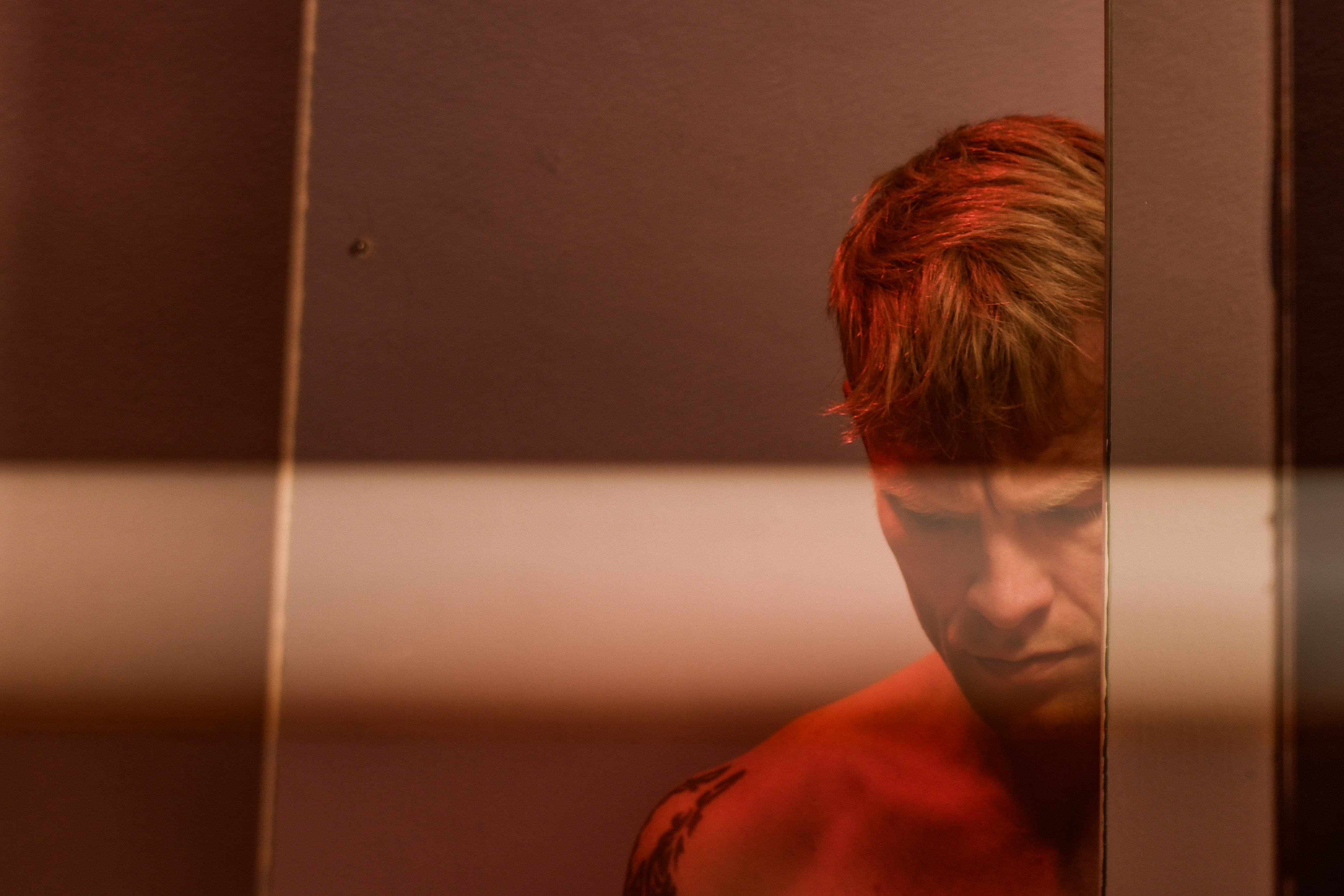 An artistic photo of Ryan Guldemond in red lighting.